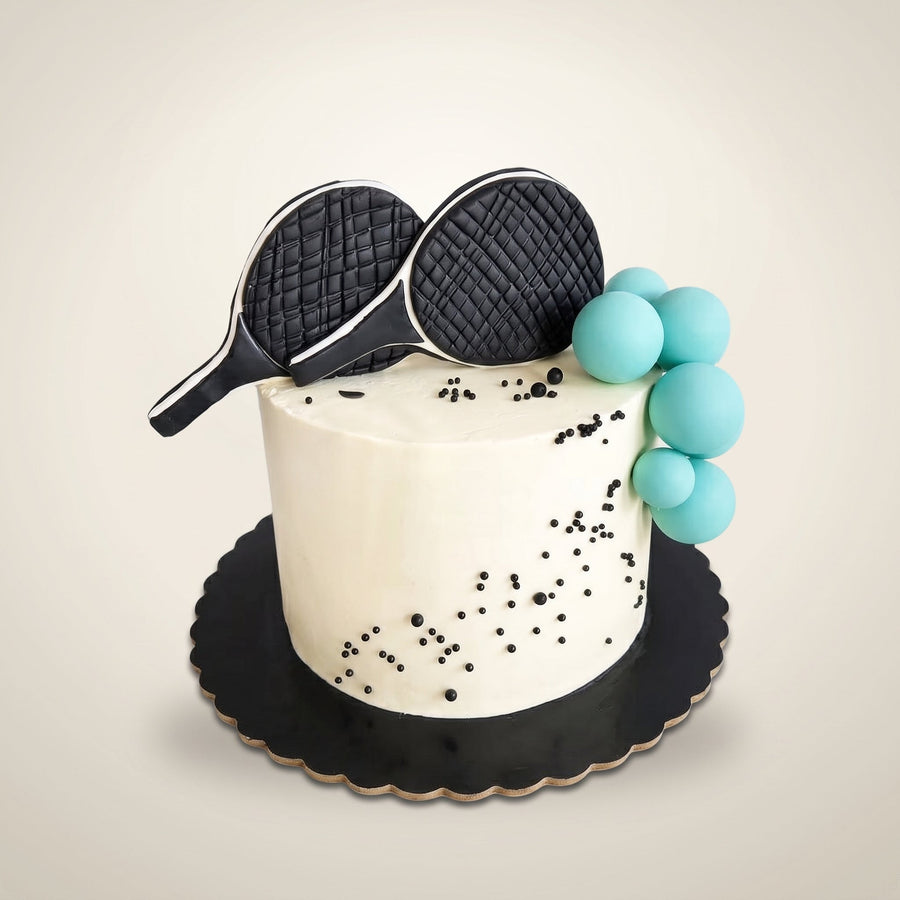 Tort Squash - kremowy tort z czarnymi rakietami do squasha i turkusowymi piłkami
